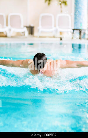 Une course d'un beau mâle musclé dans une piscine