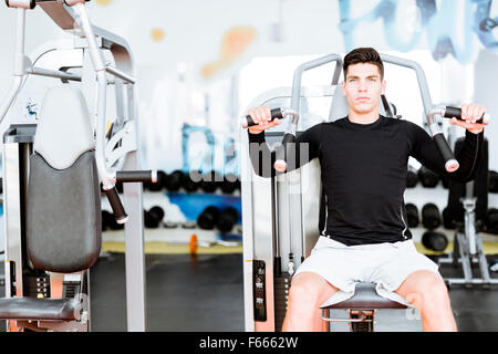 Portrait d'un beau jeune homme dans une salle de sport et de formation à la recherche vers l'appareil photo Banque D'Images