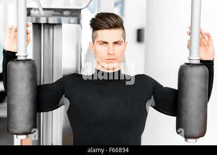 Portrait d'un beau jeune homme dans une salle de sport et de formation à la recherche vers l'appareil photo Banque D'Images