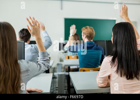 Des mains de jeunes étudiants dans une salle de classe montrant qu'ils sont prêts Banque D'Images