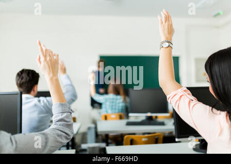 Des mains de jeunes étudiants dans une salle de classe montrant qu'ils sont prêts Banque D'Images