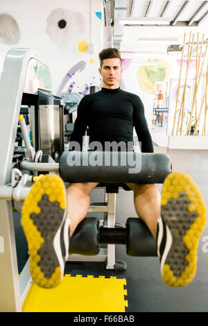 Beau jeune homme qui travaille dans une salle de sport et un mode de vie sain Banque D'Images