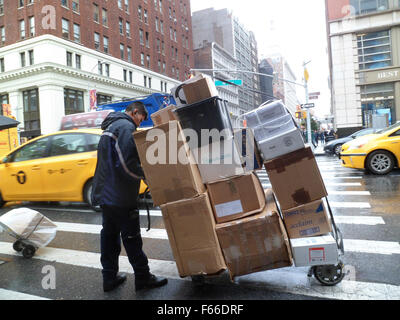 Un travailleur FedEx laden avec des livraisons dans le quartier de Chelsea, New York le Mardi, Novembre 10, 2015. FedEx a récemment annoncé qu'elle recrutera 55 000 employés saisonniers pour faire face à l'appartement de livraisons. (© Richard B. Levine) Banque D'Images