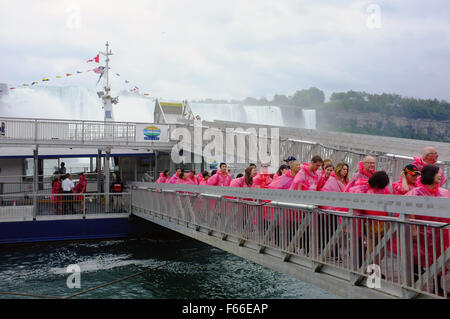 Les touristes à la sortie des ponchos bateau Hornblower après une visite en bateau des Chutes du Niagara à la célèbre cascade de l'Ontario. Banque D'Images