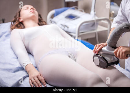 Jeune femme dans spa salon de beauté, massage à rouleaux vide de la scène Banque D'Images