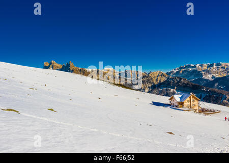 Chalet de montagne en haute altitude en face de sommets enneigés des Dolomites Banque D'Images