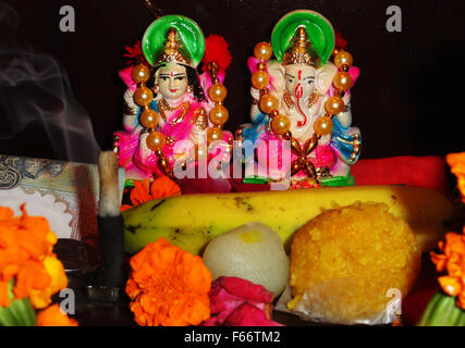 Maa Lakshmi Déesse de dévotion et Lord Ganesha Statue avec des bonbons et des fruits Banque D'Images