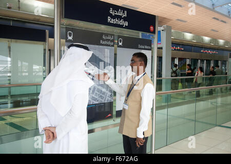 L'homme arabe étant donné l'information de membre du personnel du métro de Dubaï Banque D'Images