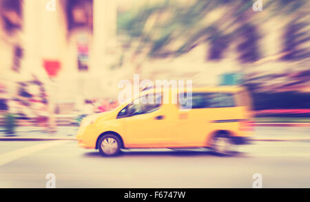 Tons Vintage motion blurred yellow taxi sur une rue. Banque D'Images