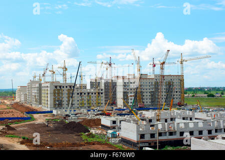 La construction de maisons en briques avec des grues Banque D'Images