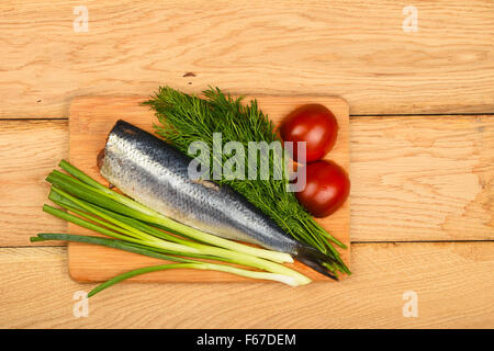 Filet de hareng aux oignons, double de l'aneth et les tomates de bamboo conseil sur la surface de la table en bois vintage Banque D'Images