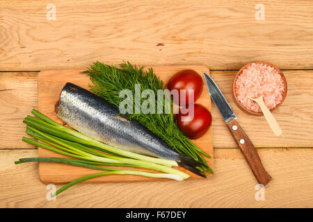 Filet de hareng aux oignons, double de l'aneth et les tomates de bamboo board gagner petit couteau, en sel rose de l'écope en bois sur bois vintage Banque D'Images