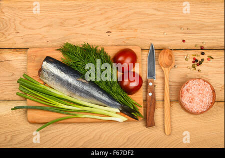 Filet de hareng aux oignons, double de l'aneth et les tomates de bamboo board gagner petit couteau, assortiment de poivre, sel rose en s en bois Banque D'Images