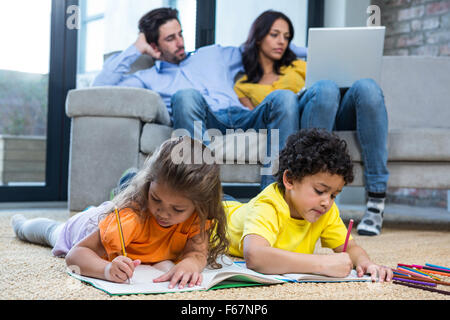 Les enfants portant sur le dessin de tapis dans la salle de séjour Banque D'Images