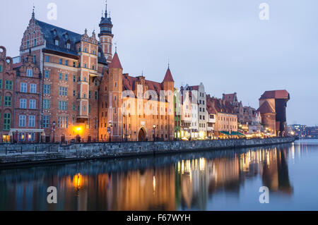 Waterfront tènements et crane reflétée sur la rivière Motlawa au crépuscule. Gdansk, Pologne Banque D'Images