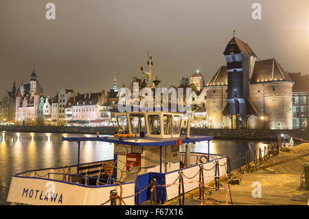 Traversier de passagers Motlawa, grue médiévale et waterfront tènements réfléchi sur la rivière Motlawa par nuit. Gdansk, Pologne Banque D'Images