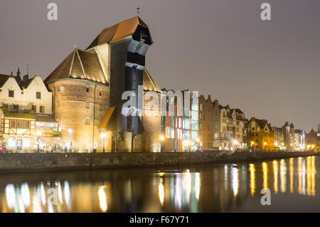 Grue médiévale et Waterfront tènements réfléchi sur la rivière Motlawa par nuit. Gdansk, Pologne Banque D'Images