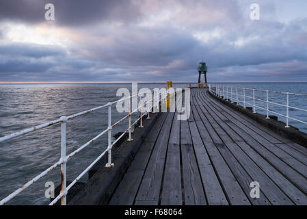 Vue le long du Whitby West Pier au crépuscule - tons bleu-gris de planches de bois, de la mer et du ciel, créer une atmosphère calme, paisible, scène. Le Yorkshire, GB, au Royaume-Uni. Banque D'Images