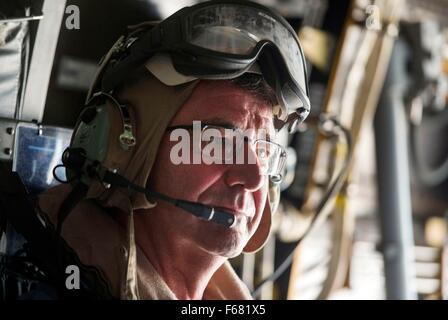 Le secrétaire américain à la défense, Ash Carter à l'écoute du trafic radio sur un casque comme il et malaisien Hishammuddin Hussein, Ministre de la Défense, voler sur un V-22 Osprey pour visiter l'USS Theodore Roosevelt le 5 novembre 2015 dans la mer de Chine du Sud. Banque D'Images