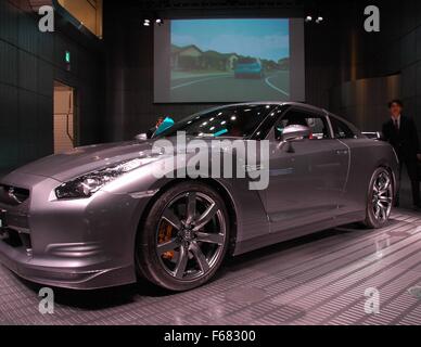 Un salaryman approuve d'un nouveau Nissan sur l'affichage à un showroom à Ginza, Tokyo, Japon Banque D'Images