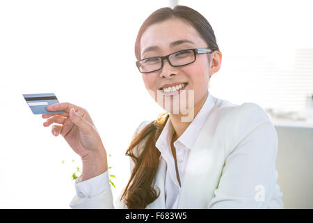 Smiling businesswoman en utilisant une carte de crédit Banque D'Images