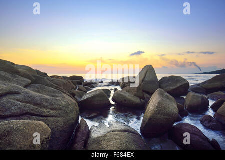 Mer vague frappé des rochers sur twilight à célèbre station à Rayong, Thaïlande Banque D'Images