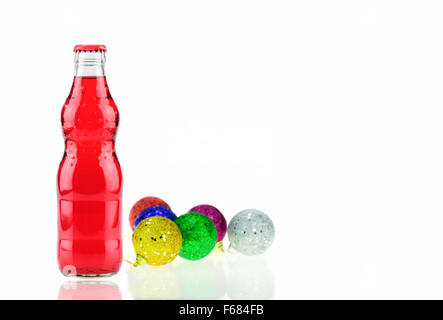 Bouteille de Fanta fraise (coca cola) Verre de soude et décoration de Noël avec hochet balle sur un fond blanc Banque D'Images