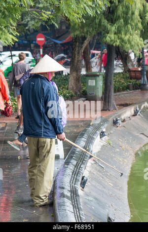 L'homme vietnamiens au périmètre de la pêche du lac Hoan Kiem à Hanoi, capitale du Vietnam Banque D'Images