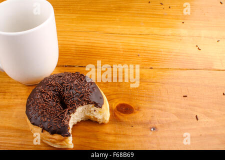 Mangé chocholate donut avec une boisson chaude au fond du bois Banque D'Images