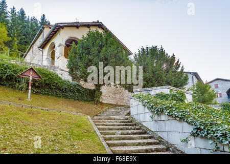 Croix de bois, près de Boston ivy dans le jardin en face de l'église dans un village de montagne médiéval en Toscane Banque D'Images