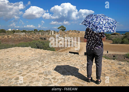 Vue arrière d'une femme touriste senior avec parapluie se ombrageant du soleil chaud sur les ruines romaines de Salamis près de Famagousta dans le nord de Chypre KATHY DEWITT Banque D'Images