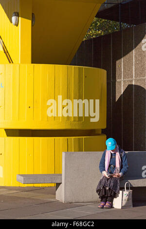 La femme en bleu, assis à côté de la pac escalier jaune, South Bank, Londres Banque D'Images