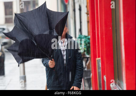 Pays de Galles Aberystwyth UK, samedi 14 novembre 2015 Un homme se débat avec son parapluie alors qu'il tente d'éviter de se faire tremper dans les rues d'Aberystwyth, comme une bande de pluie torrentielle sweeps en provenance de l'ouest dans le service d'Abigail. Ambre et rouge les avertissements sont en place pour le risque de graves inondations dans le nord du Pays de Galles et le nord ou l'Angleterre, avec jusqu'à 8" (20cm) de pluie prévue à l'automne sur sol déjà saturé dans certaines régions dans les prochaines 24 heures Crédit photo : Keith Morris /Alamy Live News Banque D'Images