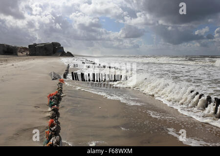 WW2 défense Nazi bunker et piquets en bois sur la plage à Houvig Strand, Søndervig, Jutland, Danemark. Banque D'Images