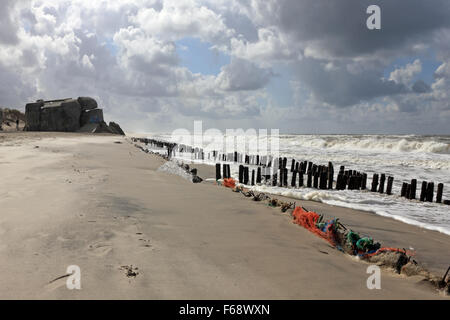 WW2 défense Nazi bunker et piquets en bois sur la plage à Houvig Strand, Søndervig, Jutland, Danemark. Banque D'Images