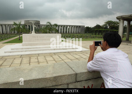 Un homme photographies la Rangoon monument au cimetière Taukkyan près de Yangon, Myanmar. Le cimetière est pris en charge par la politique commune de Banque D'Images