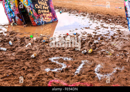 Bidons de peinture vides laissés par les gens après l'ajout de leurs étiquettes à la Cadillac Ranch public art sculpture de Amarillo, Texas. Banque D'Images