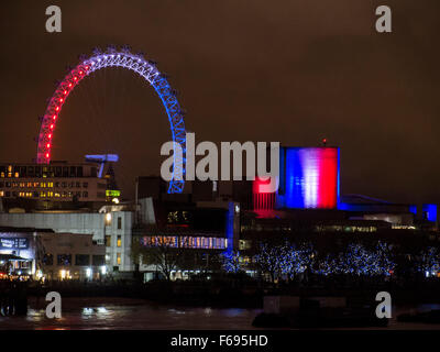 Londres, Royaume-Uni. 14 novembre 2015. Le London Eye et Théâtre National sont éclairées que Londres montre sa solidarité avec la ville de Paris par l'éclairage des principaux lieux d'intérêt avec le tricolore français. Crédit : Stephen Chung / Alamy Live News Banque D'Images