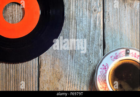 Photo de vieux disque vinyle et tasse de café sur une table en bois Banque D'Images