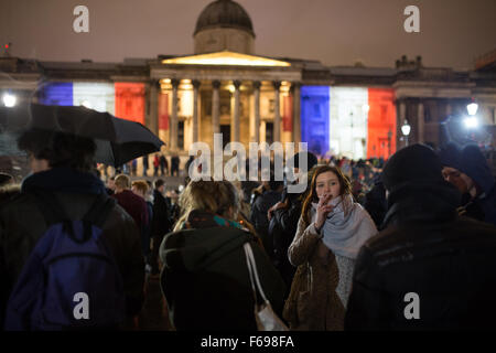 Des milliers de personnes se rassemblent à Trafalgar Square, Londres, Royaume-Uni en solidarité avec le peuple français après les attentats à Paris, où au moins 130 personnes ont été tuées par une série d'attaques terroristes. Les Fontaines de Trafalgar Square sont allumés avec le tricolore français. La foule allumé des bougies et ont chanté la Marseillaise, l'hymne national français Banque D'Images