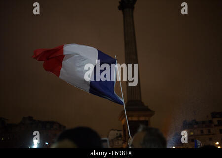 Des milliers de personnes se rassemblent à Trafalgar Square, Londres, Royaume-Uni en solidarité avec le peuple français après les attentats à Paris, où au moins 130 personnes ont été tuées par une série d'attaques terroristes. Les Fontaines de Trafalgar Square sont allumés avec le tricolore français. La foule allumé des bougies et ont chanté la Marseillaise, l'hymne national français Banque D'Images