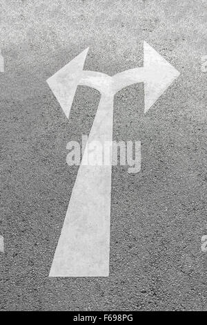 Un symbole de flèche noire sur une route asphaltée surface. Banque D'Images