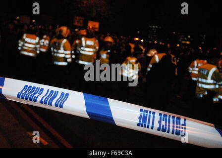 Cordon de police tape derrière une ligne d'agents d'une manifestation à Londres, au Royaume-Uni, en mars 2011. Banque D'Images