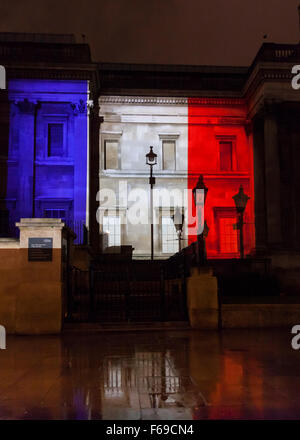 Londres, Royaume-Uni. 14 novembre 2015. La Galerie nationale est allumé dans le tricolore couleurs rouge, blanc et bleu comme des milliers de personnes se rassemblent à Trafalgar Square pour payer leur respect aux victimes en France et de montrer leur solidarité à la suite des attaques de Paris Banque D'Images