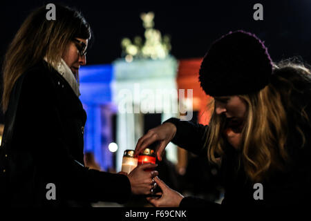 Berlin, Allemagne. 14Th Nov, 2015. Les gens allument des bougies lors d'un rassemblement au mémorial des victimes tuées dans les attentats de vendredi à Paris que la porte de Brandebourg est éclairé dans les couleurs nationales près de Ambassade d'Allemagne, à Berlin, Allemagne, le 14 novembre 2015. Credit : Zhang Fan/Xinhua/Alamy Live News Banque D'Images