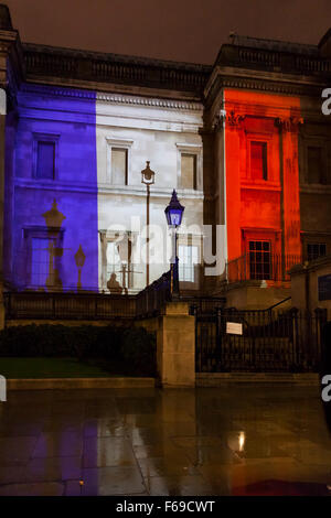 Londres, Royaume-Uni. 14 novembre 2015. La Galerie nationale est allumé dans le tricolore couleurs rouge, blanc et bleu comme des milliers de personnes se rassemblent à Trafalgar Square pour payer leur respect aux victimes en France et de montrer leur solidarité à la suite des attaques de Paris Banque D'Images