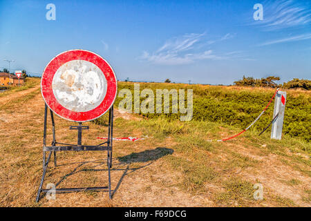 Panneaux de circulation et les routes de campagne - une limite de vitesse de 30 mph s signer devenir un panneau interdisant l'accès à la piste sur le bord d'une rivière Banque D'Images