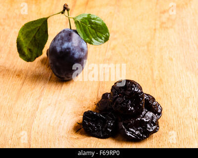 Une alimentation saine, bonne cuisine. Libre de prunes séchées et de fruits pruneaux frais sur la table rustique en bois Banque D'Images