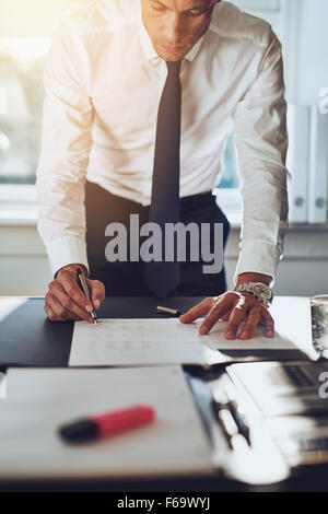 L'homme d'affaires la conclusion d'une affaire la signature de documents office portant chemise blanche et cravate Banque D'Images