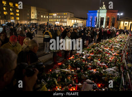 Berlin, Allemagne. 15 Nov, 2015. Brandenburger Tor s'allume à la tri-colore comme pleureuses se rassembler devant l'ambassade de France à Berlin, Allemagne, 15 novembre 2015. Après les attaques dont au moins 129 personnes ont été tuées dans une série d'attaques terroristes à Paris le 13 novembre 2015, de nombreuses personnes se sont rassemblées pour rendre hommage à l'ambassade de France à la Pariser Platz à Berlin. La police a encerclé la zone entourant l'ambassade. Photo : KAY NIETFELD/DPA/Alamy Live News Banque D'Images